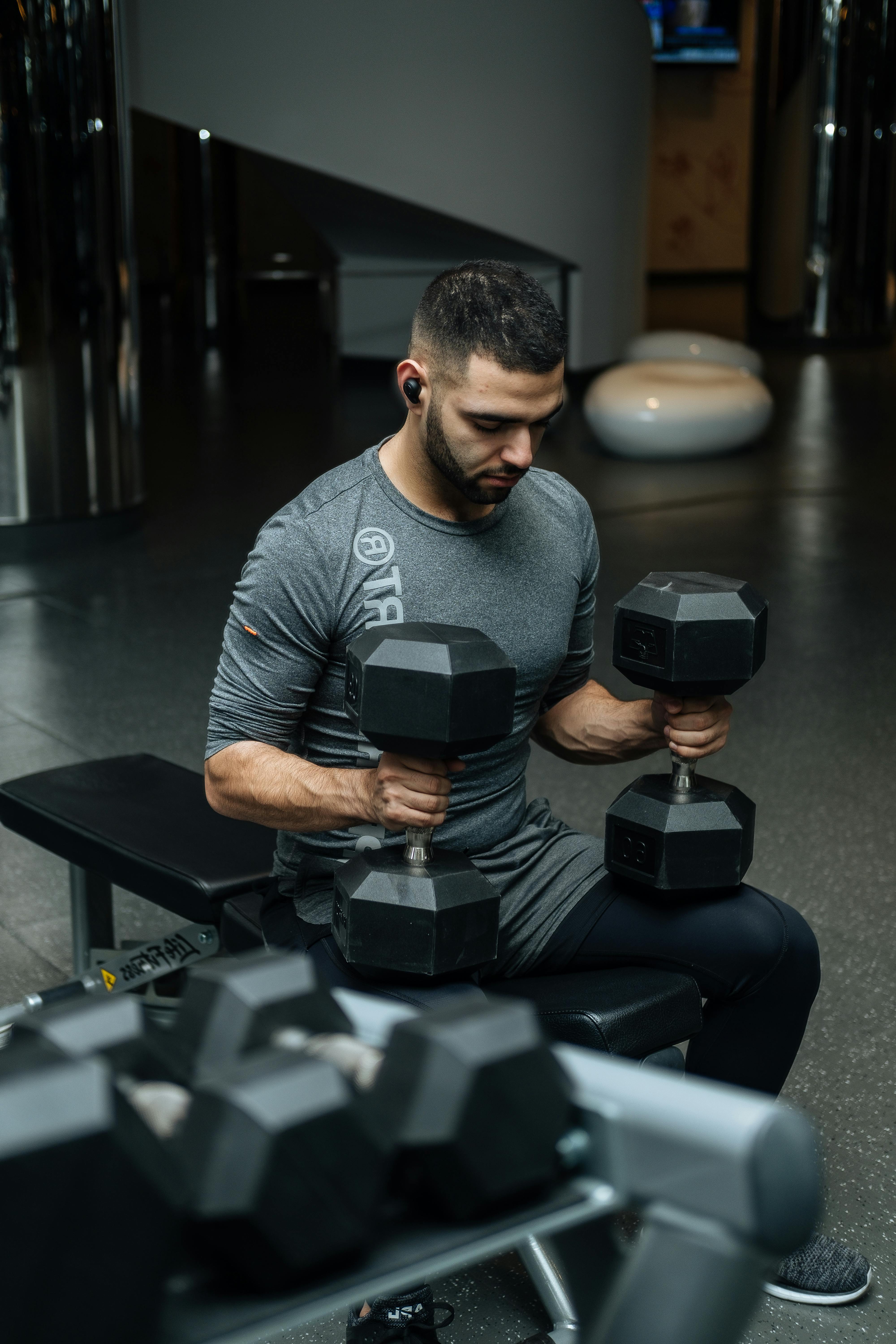 pexels-photo-3490348-3490348 Adult man lifting dumbbells in a gym, focused on strength training workout.